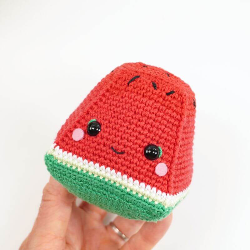 Sandy la sandía de amigurumi tejida a crochet sobre fondo claro